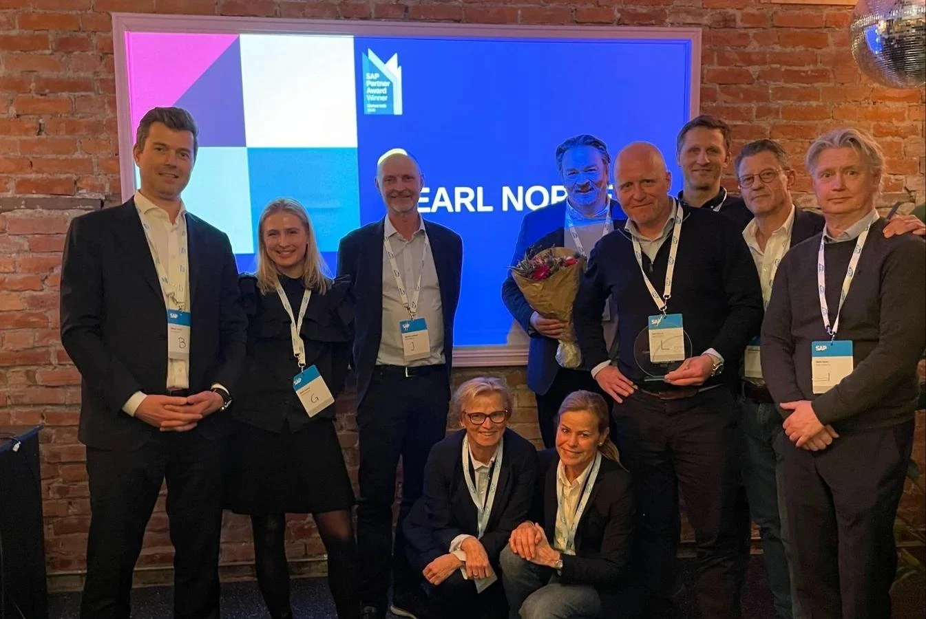 Pearl Group team members posing together at the SAP Partner Award ceremony with the Pearl Norway award screen in the background.