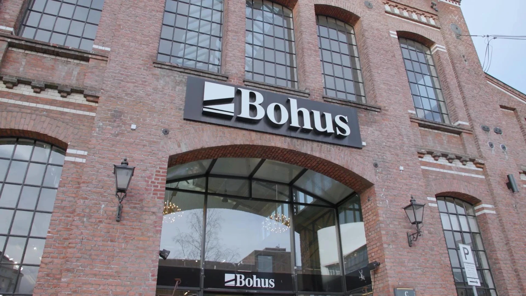 Exterior of a Bohus furniture store with branded signage on a red brick building facade with large arched windows.